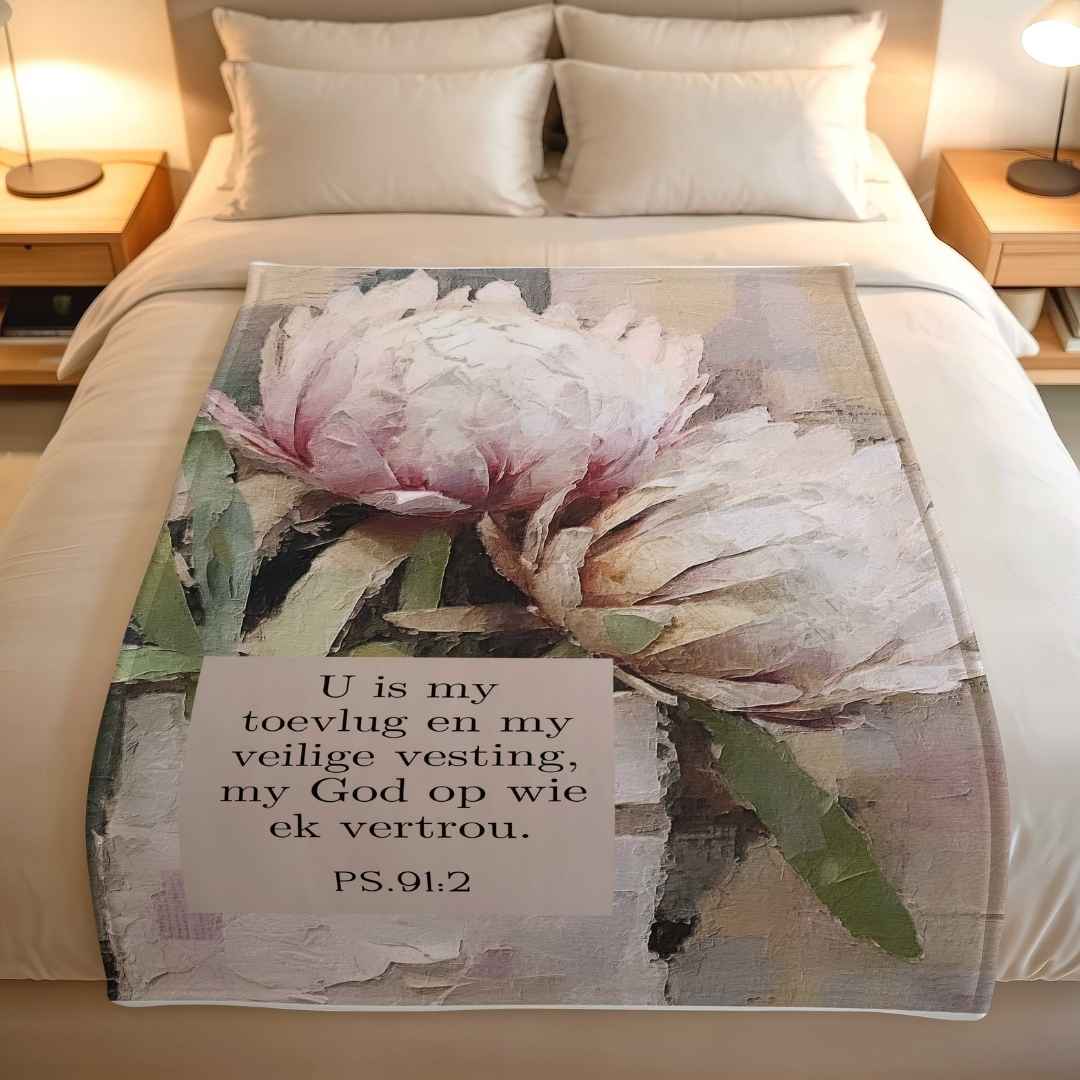 Afrikaans Psalm 91 fleece blanket with soft pink protea flowers and the Bible verse "U is my toevlug en my veilige vesting" printed on a lightweight throw blanket.