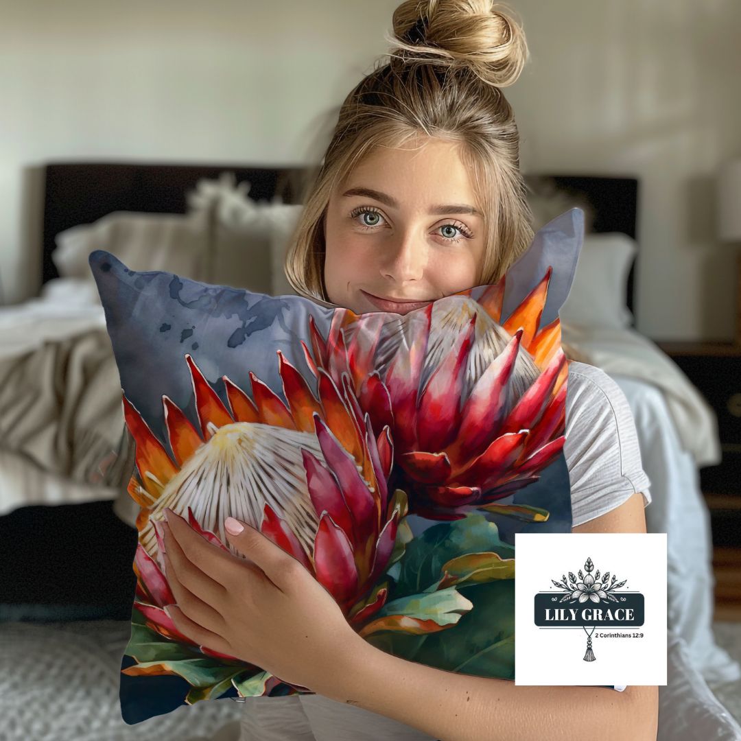 Soft fleece blanket throw with red protea flower design paired with protea scatter cushion cover on neutral armchair.
