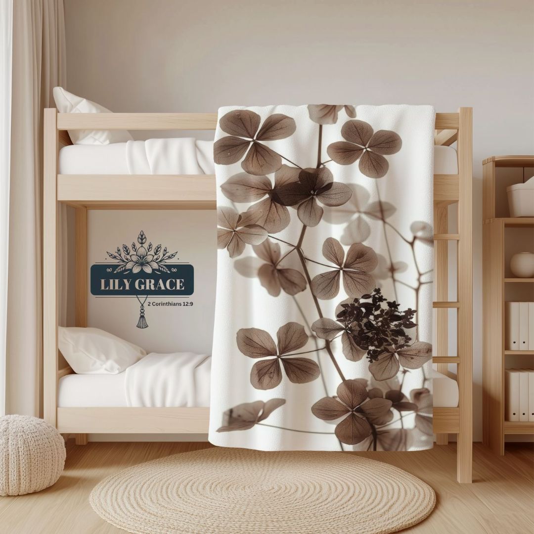 Hydrangea floral fleece blanket draped over a bed in soft brown tones
