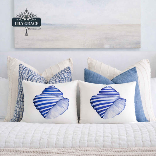 Blue and white shell scatter cushion cover on a chair in a light coastal lbed4oom