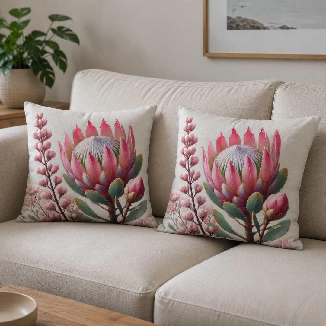 Matching protea-print cotton cushion covers displayed naturally on a beige living-room sofa