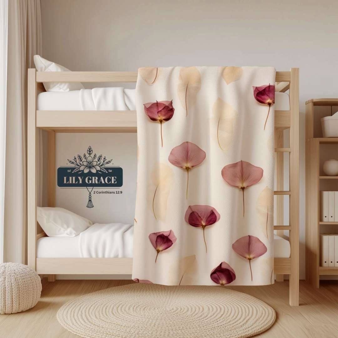 Pink fleece blanket draped over a bunk bed with soft floral petal design
