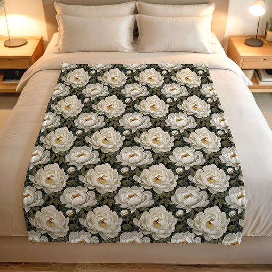 Floral lightweight fleece blanket with white peony-style blooms on a dark botanical print.
