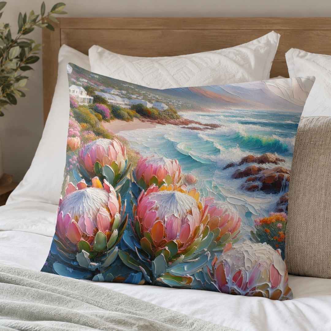 Coastal floral cotton cushion cover with pink king proteas and blue ocean waves styled on a bed