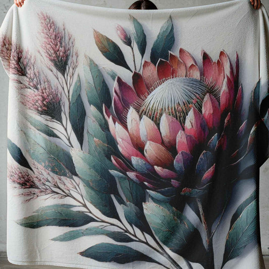 Lightweight fleece blanket with large protea flower design styled on a white bed in a South African bedroom